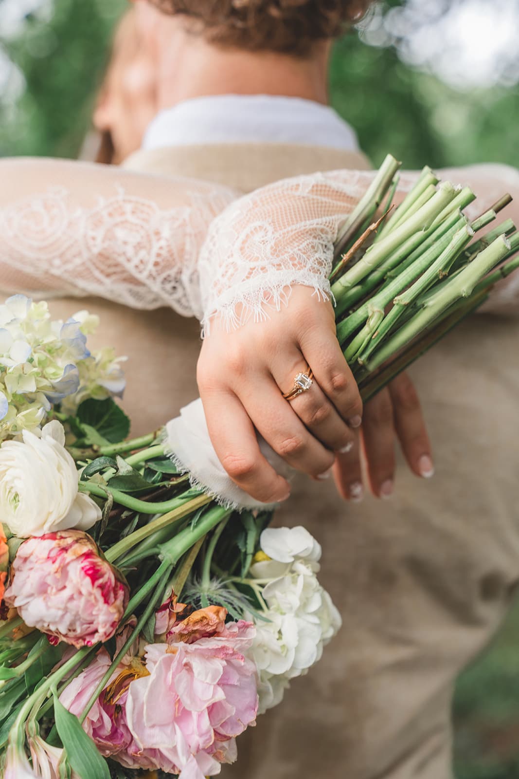 Bride holding her bouquet, engagement ring in frame